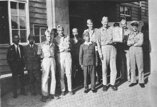 The survey team at Nagasaki. Stafford Warren is the tall man holding a doll given to him as a gift.
