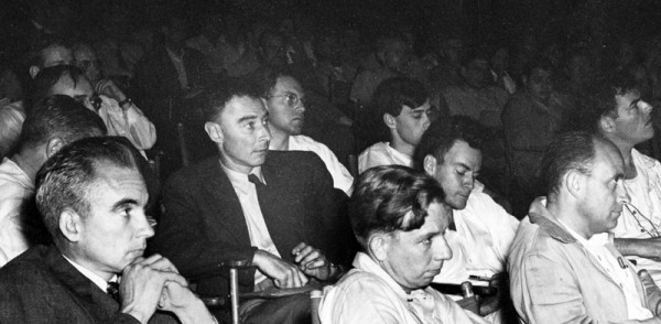 Los Alamos colloquium from 1946, featuring (foreground, from left-to-right), Norris Bradbury, J. Robert Oppenheimer, John Manley, Richard Feynman, and Enrico Fermi. This version is cropped from the scanned copy at the Emilio Segrè Visual Archives. I will note that unlike the more common copies of this photo that have circulated, you can actually get a sense for how many other people were in the room — it looks like a really packed house.